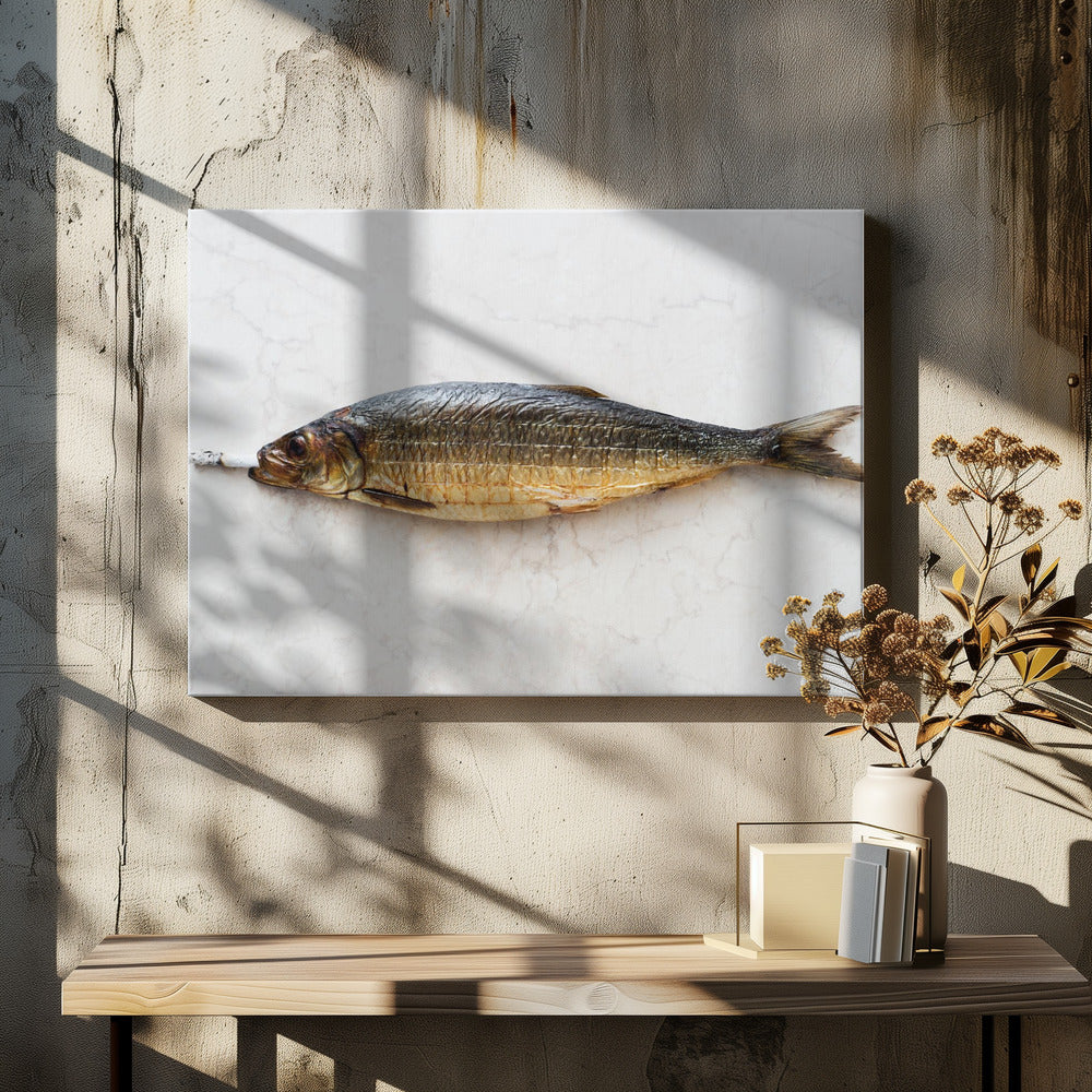 A surreal photograph of a whole smoked fish with a cigarette butt in its mouth, laying horizontally on a white marble surface, all within a silver frame. Wall Art