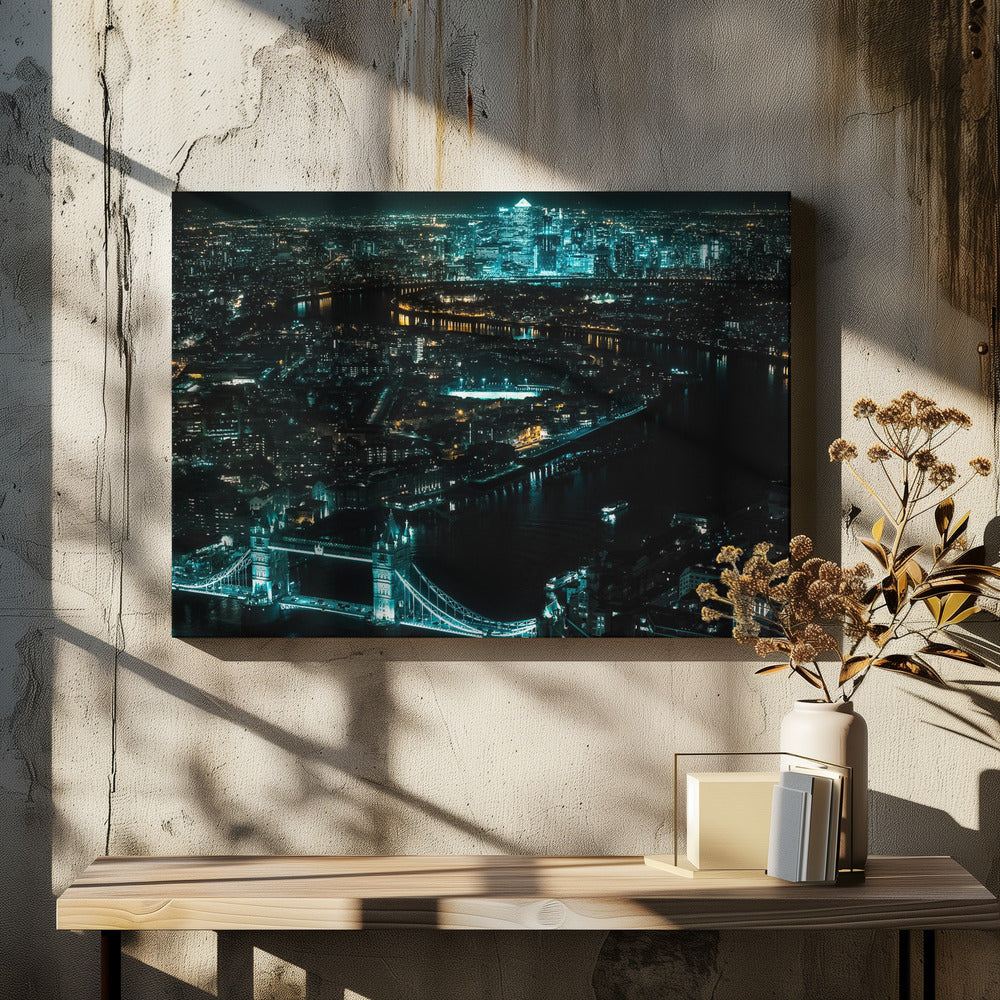 A framed aerial photograph of London at night, featuring the iconic Tower Bridge illuminated in bright teal in the foreground and the glowing skyscrapers of Canary Wharf across the River Thames in the background. Artwork
