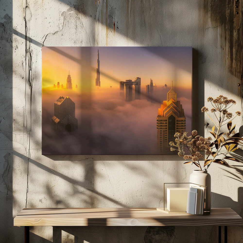 An aerial photograph of the Dubai skyline shrouded in a thick blanket of fog at sunrise. The warm golden light illuminates the tops of several skyscrapers, including the Burj Khalifa, which pierce through the clouds creating a dreamlike and majestic scene. Print