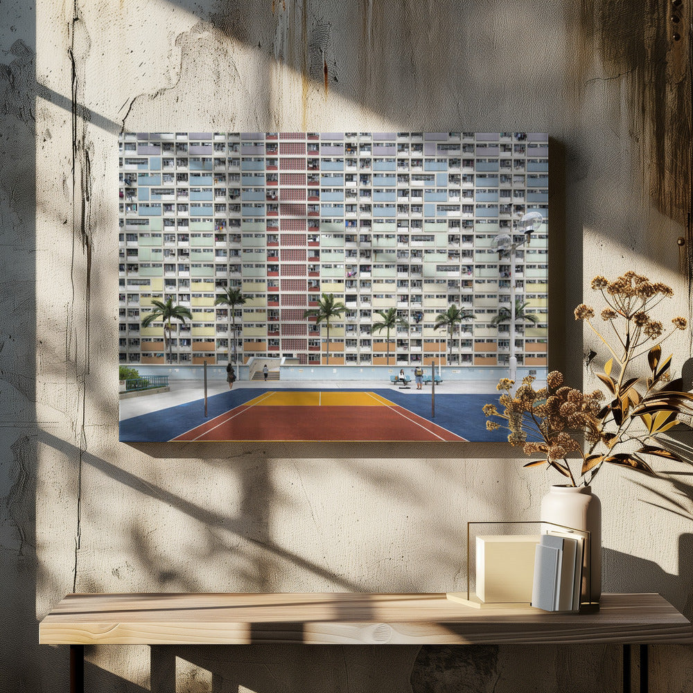 A wide, symmetrical photograph of the colorful Choi Hung Estate apartment building in Hong Kong, featuring a facade with a repeating pattern of pastel blue, green, yellow, and orange blocks. In front of the building is a vibrant basketball court painted in bold sections of blue, red, and yellow, with several palm trees lining the courtyard. Print