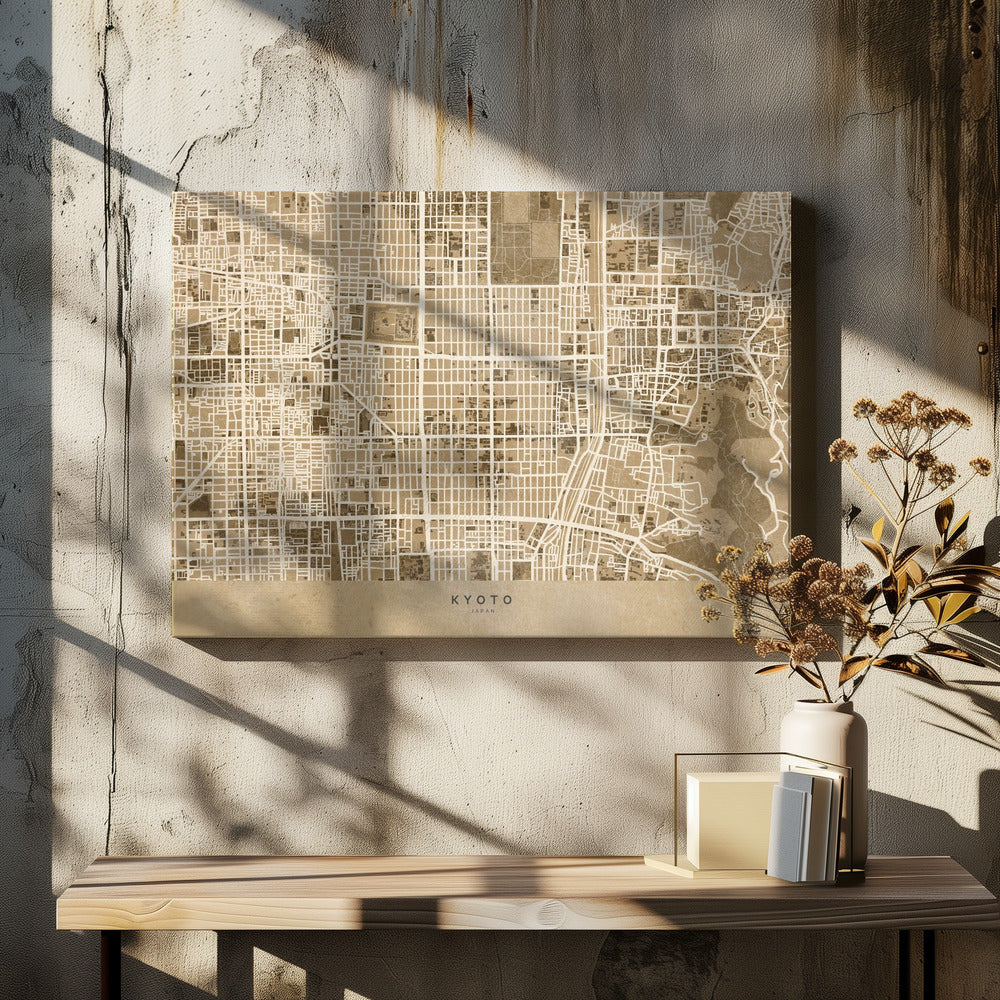 A framed, stylized map of Kyoto, Japan, in shades of brown and beige. The city streets are illustrated as a complex grid of off-white lines against a textured brown background. At the bottom, a solid beige banner contains the text 'KYOTO' and 'JAPAN' in a modern sans-serif font. The artwork is surrounded by a brushed silver frame. Artwork