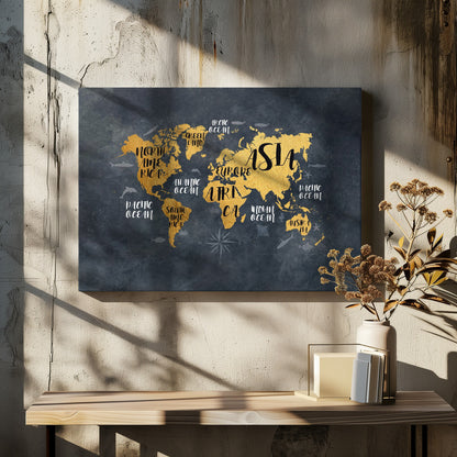 A modern world map artwork with gold leaf continents set against a textured dark gray background. Continents and oceans are labeled with decorative typography, and subtle illustrations of sea life swim in the oceans. The art is presented in a silver frame. Artwork