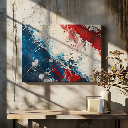 A close-up of an abstract painting in a silver frame, featuring a dynamic composition of red, white, and blue. Thick strokes of paint are splattered and swirled across the canvas, with a large area of deep blue on the left, a bold patch of bright red on the upper right, and a field of off-white in the middle. The piece has a textured, energetic quality. Artwork
