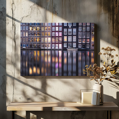 A framed photograph of colorful Amsterdam canal houses at night, their illuminated windows casting vibrant, shimmering reflections on the water below. Artwork