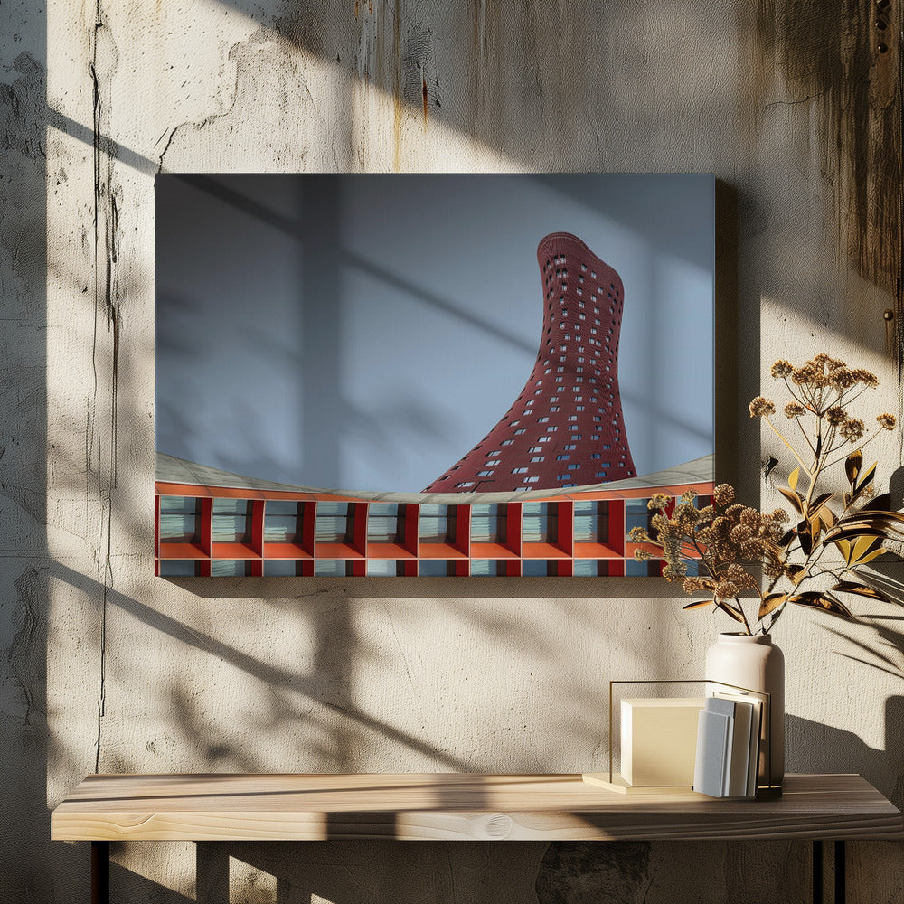 A modern architectural photograph showing a curved, maroon skyscraper twisting towards the sky against a gradient grey background. A lower, orange, grid-like building curves along the bottom of the frame. The entire scene is enclosed in a silver frame. Poster
