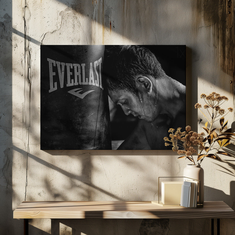 A dramatic black and white close-up photograph of an exhausted boxer resting his head against a heavy Everlast punching bag, with sweat dripping down his face and neck. Poster