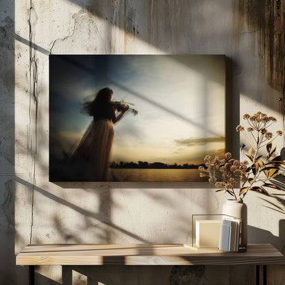 An artistic, framed photograph with motion blur capturing the silhouette of a woman in a long flowing skirt playing the violin by a lake against a dramatic sunset sky. Poster