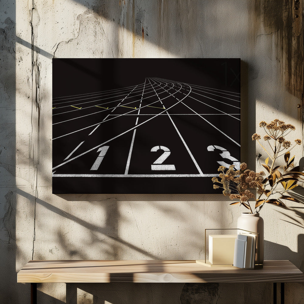 A framed, high-contrast graphic of a black running track from a low-angle perspective at the starting line. White lines delineate the lanes, with the numbers 1, 2, and 3 stenciled in the foreground. The track curves and recedes into the distance, creating a strong sense of perspective. Decor