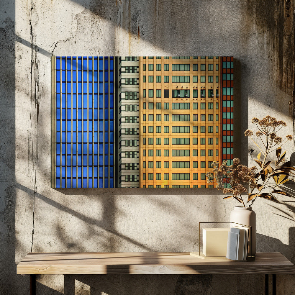 An abstract architectural photograph showing the colorful gridded facades of three adjacent skyscrapers, featuring a blue-windowed building, a white building, and a yellow building, all contained within a silver frame. Wall Art