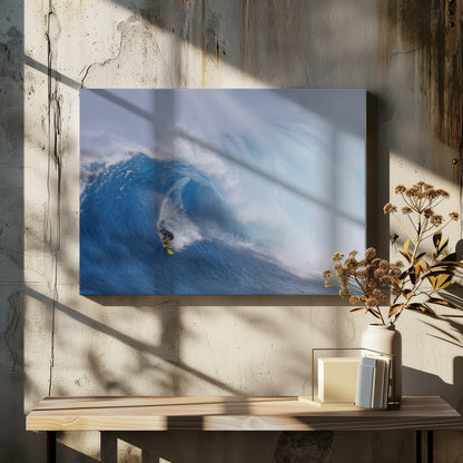 A framed photograph of a professional surfer skillfully riding down the steep face of a massive, cresting blue ocean wave, surrounded by white sea spray. Decor