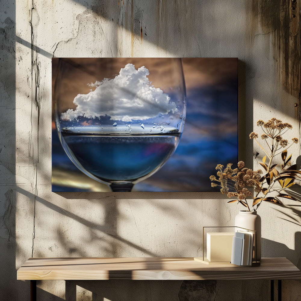 A surreal close-up of a wine glass holding blue liquid and a single white cloud, with water droplets on the glass, set against a blurred background and enclosed in a silver frame. Print