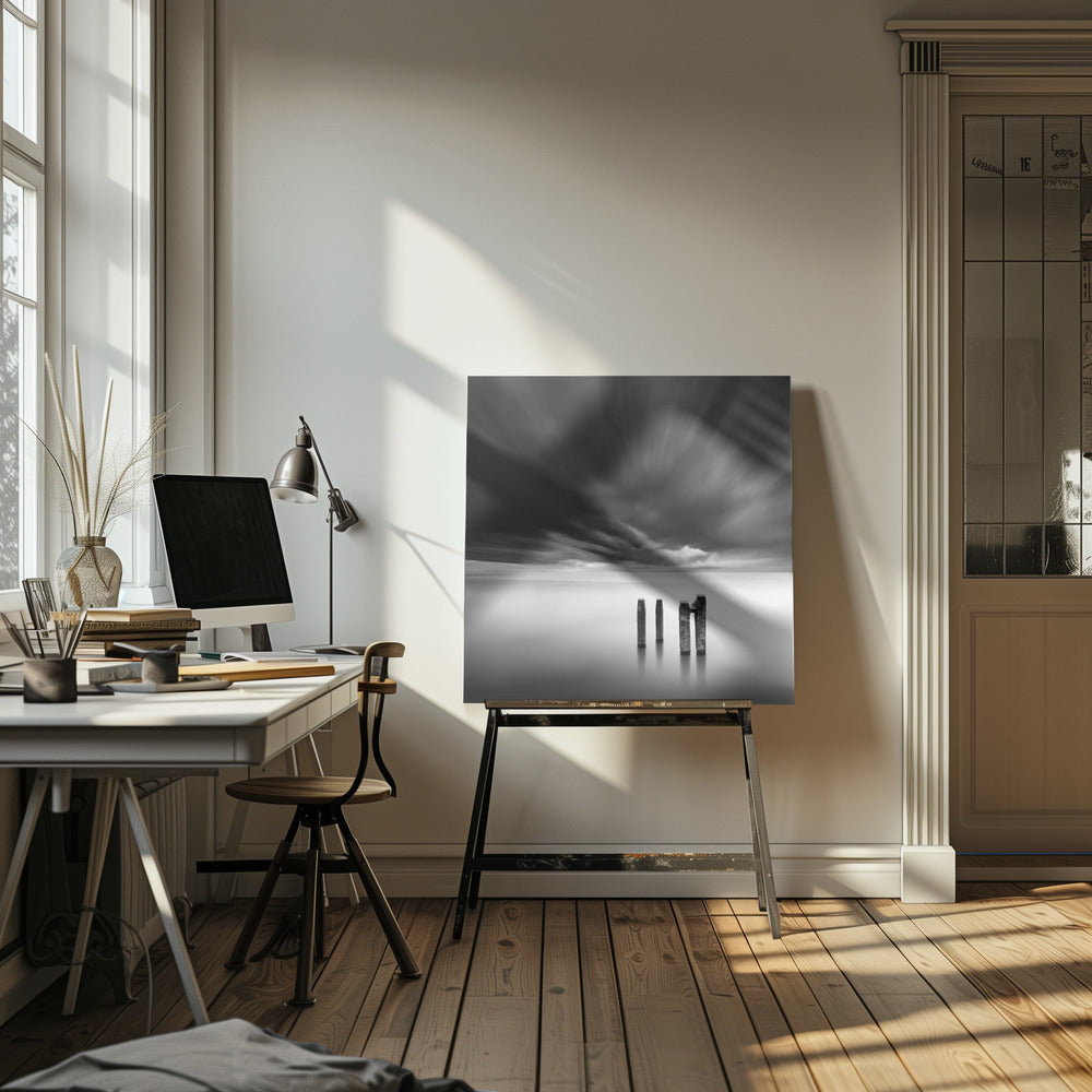 A framed, square, black and white long-exposure photograph of a minimalist seascape. Four dark wooden pilings emerge from still, misty water under a dramatic, streaked sky of dark clouds. Wall Art