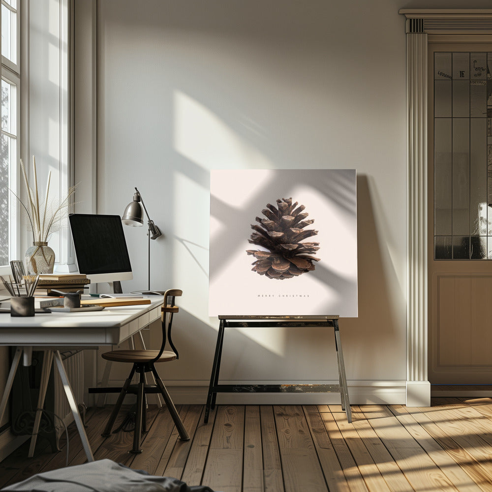 A minimalist art print featuring a single brown pinecone centered on an off-white background. The words 'MERRY CHRISTMAS' are printed in a simple, spaced-out font below the pinecone. The entire image is enclosed in a light wood frame. Artwork