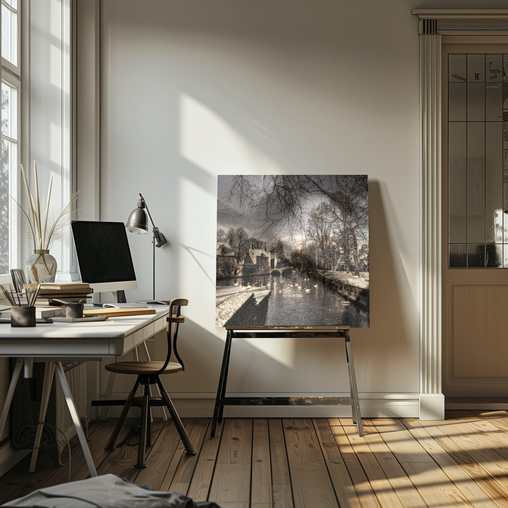 A vintage-style, framed photograph of a European canal scene in winter. Historic buildings and bare trees line the partially frozen canal, where several white swans are swimming. A light dusting of snow covers the canal banks and rooftops under a cloudy sky. Wall Art