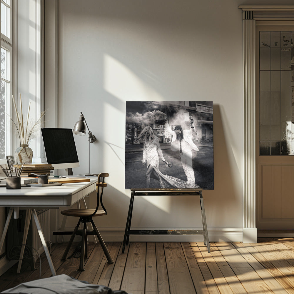 A black and white photograph in a light wood frame showing a stylish couple walking down a street. The woman wears a sparkling sequin gown, and the man, in a white suit with a long beard, triumphantly raises his arms, holding a smoke bomb and a bottle with a rose. Decor
