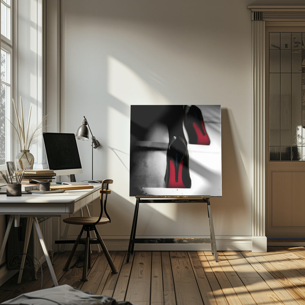 A dramatic, low-angle, black and white photograph focusing on the back of a person wearing glossy black high heels with vibrant red soles, all set within a light wood frame. Artwork