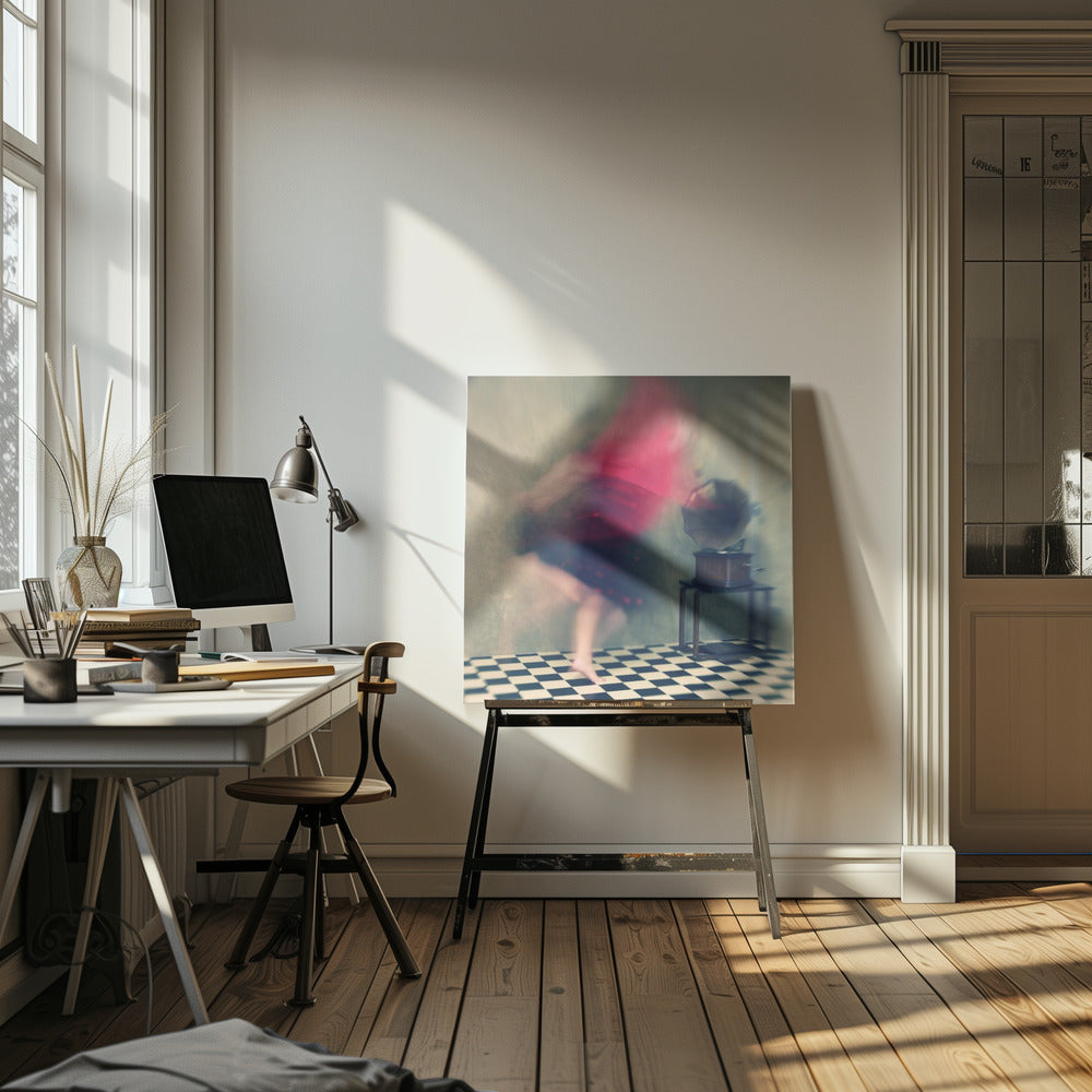 A motion-blurred, artistic photograph in a light wood frame showing a woman dancing barefoot on a black and white checkered floor. She wears a bright red top and a dark skirt, both blurred by her movement. Next to her stands a vintage gramophone on a small table, against a muted, textured wall, creating a dreamy, nostalgic atmosphere. Print