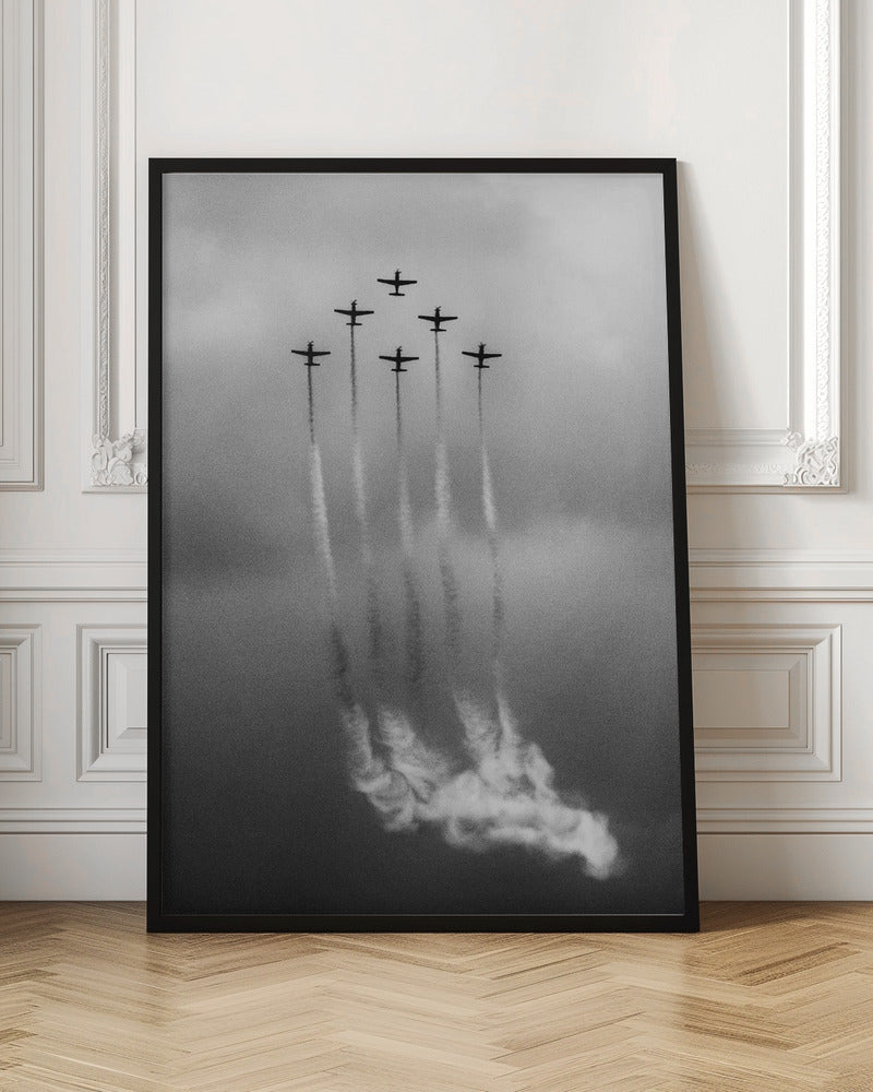 A grainy black and white photo of six airplanes flying in a V-formation against a cloudy sky. Each plane leaves a long, white smoke trail that billows at the bottom of the frame. The image is presented within a black border. Print