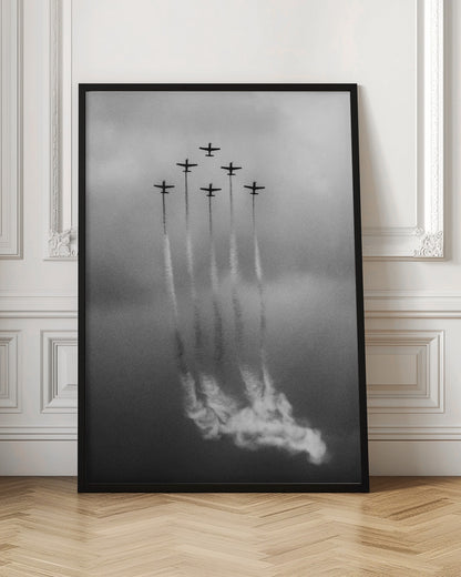 A grainy black and white photo of six airplanes flying in a V-formation against a cloudy sky. Each plane leaves a long, white smoke trail that billows at the bottom of the frame. The image is presented within a black border. Print