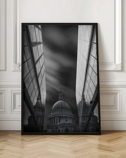 A dramatic black and white, low-angle photograph of St. Paul's Cathedral in London, framed between two modern, reflective glass skyscrapers. A long exposure effect blurs the clouds in the sky, creating streaks of light and shadow behind the cathedral's dome. Poster