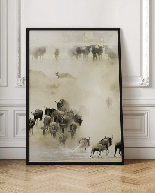 A hazy, sepia-toned photograph depicting the great wildebeest migration. A large herd is seen crossing a river, kicking up dust and water, creating a dynamic and atmospheric scene of wildlife in motion. Artwork