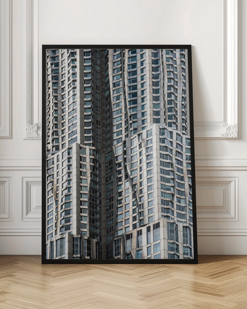 A close-up photograph of the facade of a modern skyscraper with an undulating, wave-like metallic exterior. The building is filled with windows that reflect the light, creating a dynamic pattern of highlights and shadows, all captured within a black frame. Print