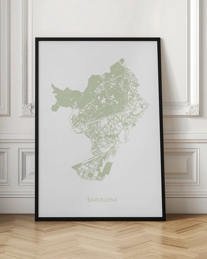 A minimalist art print of a Barcelona city map, rendered in a pale sage green on a white background. The print is framed in a simple black frame, with the city's name 'BARCELONA' typed at the bottom. Poster