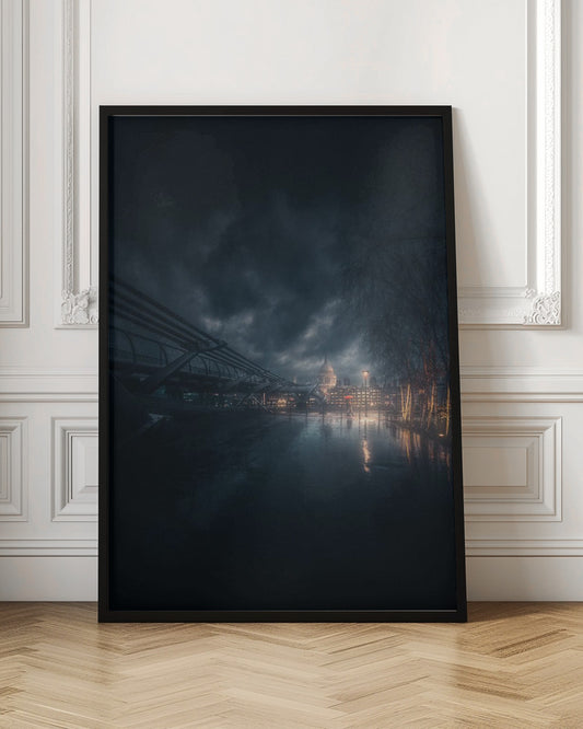 A moody, atmospheric night photograph of London, featuring the Millennium Bridge stretching across a wet surface towards the illuminated St. Paul's Cathedral under a dark, stormy sky. City lights reflect on the wet ground, and trees with warm lights line the right side of the frame. Artwork