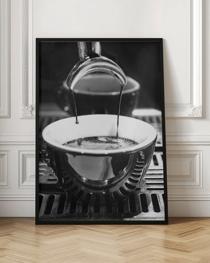 A close-up, black and white artistic photograph capturing the moment two streams of dark espresso pour from a portafilter into a waiting cup on a coffee machine's drip tray. Wall Art