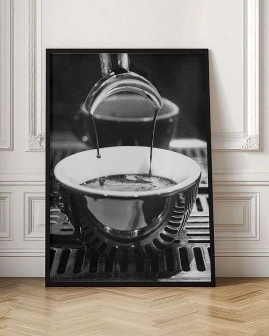 A close-up, black and white artistic photograph capturing the moment two streams of dark espresso pour from a portafilter into a waiting cup on a coffee machine's drip tray. Wall Art