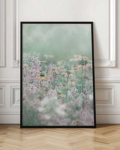 A soft-focus, dreamy photograph of a field of wildflowers, including pale coneflowers with green centers and fuzzy pink thistles, set against a hazy, light green background, creating an ethereal and serene atmosphere. The image is shown within a thin black frame. Poster