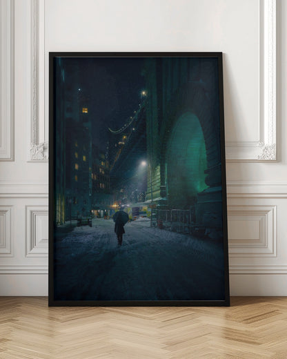 A lone person holding an umbrella walks down a snow-covered street at night, dwarfed by the massive, green-lit stone archway of the Brooklyn Bridge as snow falls around them. Print