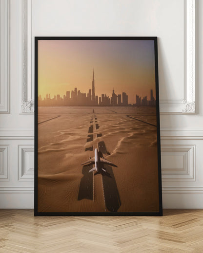 A surreal high-angle view of a white airplane on a runway partially buried in desert sand, pointing towards the Dubai city skyline during a hazy orange sunset. Decor
