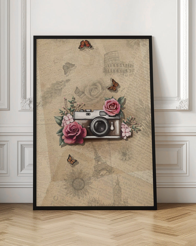 A vintage-style collage art piece in a black frame. The central focus is a retro camera adorned with pink and magenta roses and green leaves. The background is a sepia-toned collage of old newspaper or book pages, with faint illustrations of European landmarks like the Colosseum and the Eiffel Tower, along with butterflies and flowers. Poster