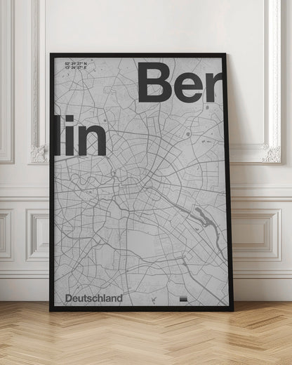 A minimalist, framed poster of a street map of Berlin, Germany. The map is rendered in shades of gray, with large, bold black text spelling 'Berlin' overlaid on the map. The city's coordinates and the word 'Deutschland' are also included in a clean, modern font. Wall Art