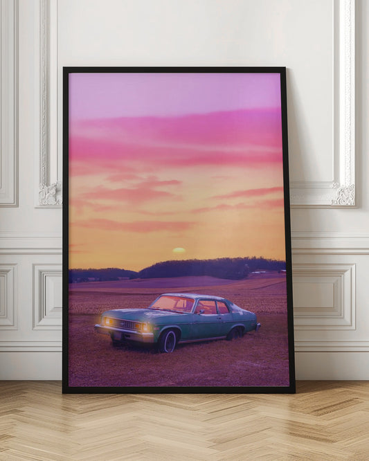 A vintage green muscle car is parked in a purple-hued field under a vibrant sunset sky that blends from orange to a vivid pink. The car's headlights are glowing, and the sun is setting behind distant hills, creating a dreamy, retro atmosphere. Decor