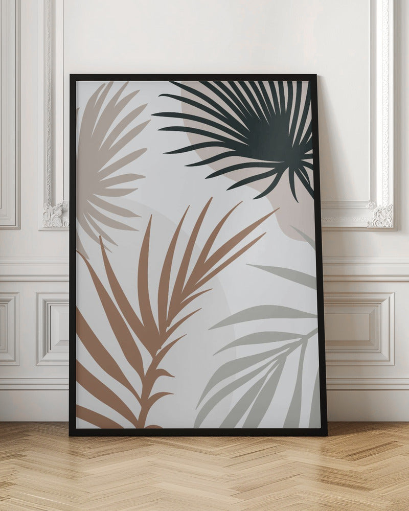 A modern art print in a black frame featuring stylized silhouettes of palm leaves. The fronds are colored in dark green, brown, beige, and light gray, overlapping on a light background with faint, large, muted pink circles. Print