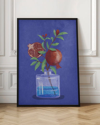 A vibrant illustration of a pomegranate branch in a clear glass vase against a deep blue, textured background. The branch features bright green leaves, a whole red pomegranate, and another cut in half to show its seeds. Decor