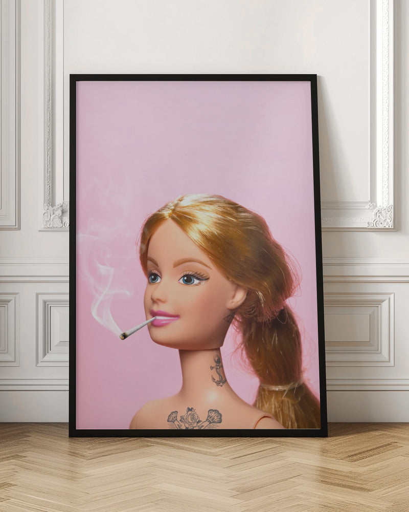 A close-up photograph of a blonde doll, resembling Barbie, with tattoos on her neck and chest, smoking a joint against a solid pink background. Smoke curls upwards from the lit cigarette in her pink-lipsticked mouth. Artwork