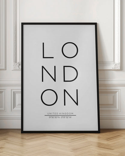 A minimalist black and white typographic poster featuring the word 'LONDON' arranged vertically in a modern sans-serif font. Below the city name, it displays 'UNITED KINGDOM' and its geographic coordinates, all enclosed within a thin black frame. Poster