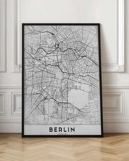 A minimalist black and white poster of a street map of Berlin, Germany. The map's intricate network of roads and waterways is depicted with black lines on a white, slightly textured background. The artwork is enclosed in a simple black frame, with the word 'BERLIN' printed in bold, black capital letters at the bottom center. Wall Art
