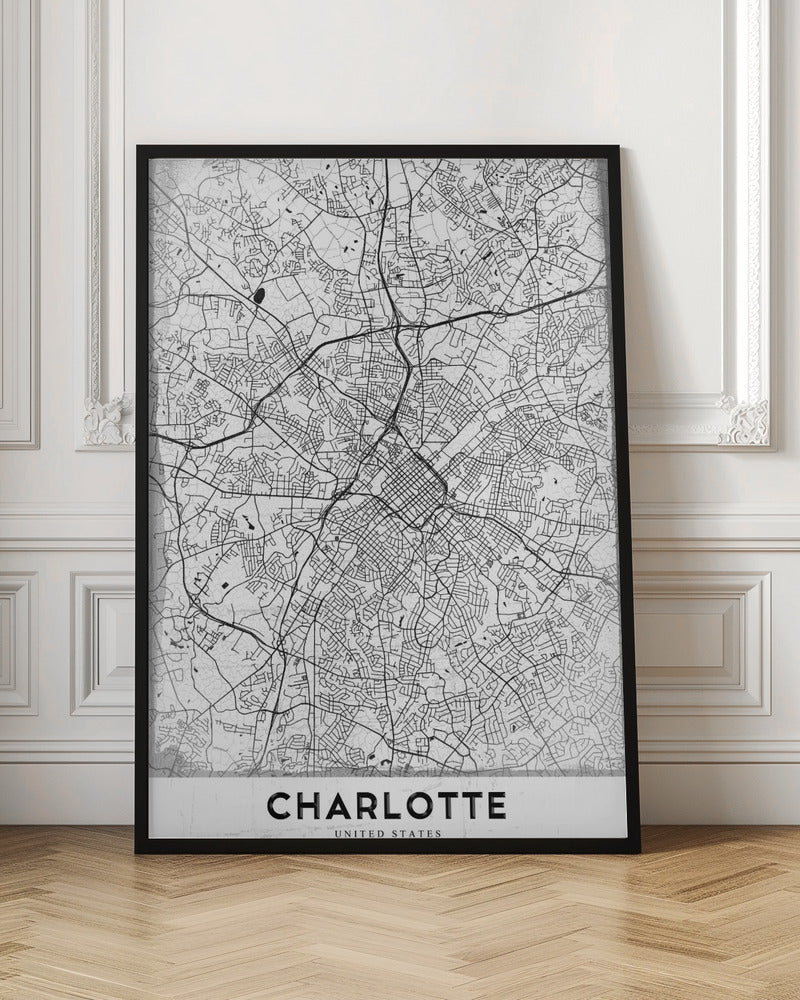 A minimalist black and white map of Charlotte, North Carolina, displayed in a black frame. The map details the intricate network of city streets and highways. At the bottom, a white banner features the city's name 'CHARLOTTE' in a bold, black, sans-serif font. Poster