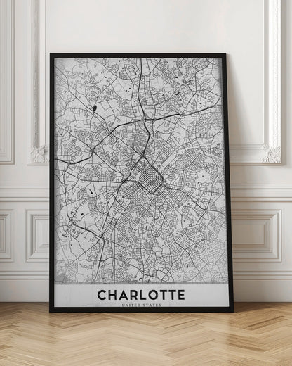A minimalist black and white map of Charlotte, North Carolina, displayed in a black frame. The map details the intricate network of city streets and highways. At the bottom, a white banner features the city's name 'CHARLOTTE' in a bold, black, sans-serif font. Poster