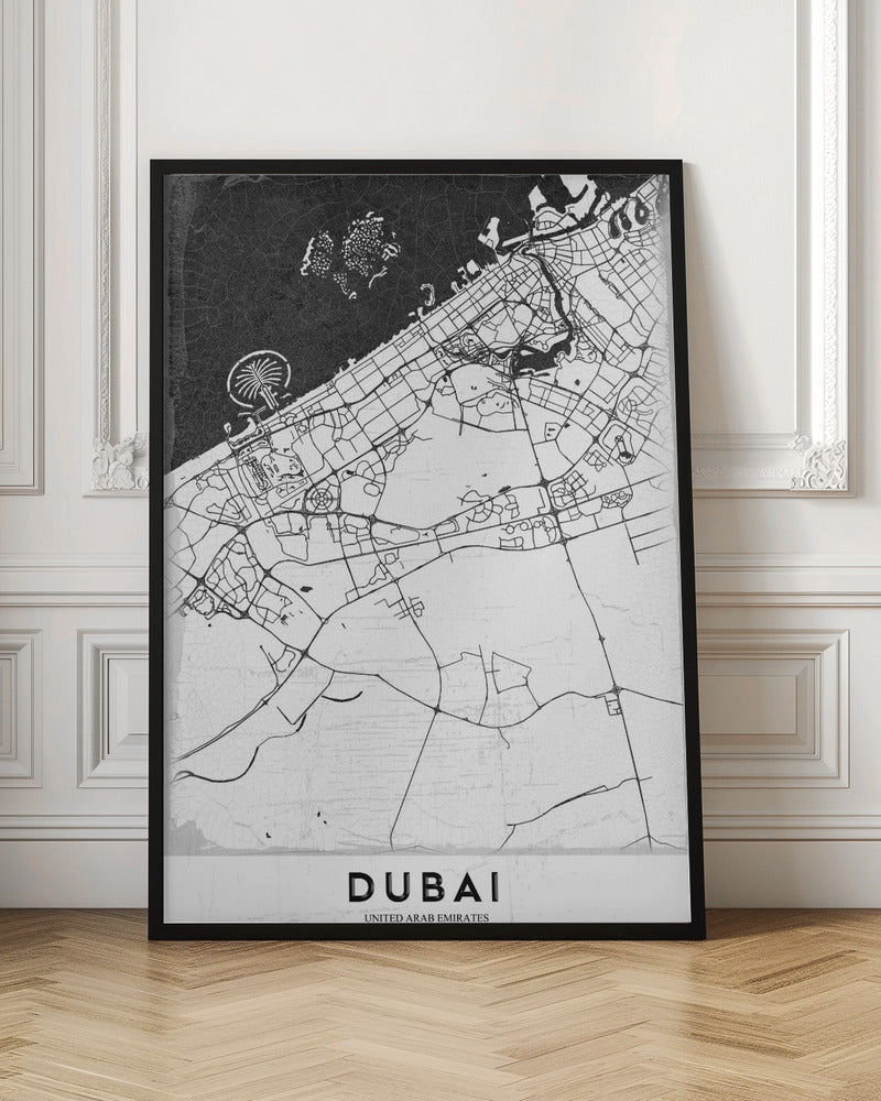 A minimalist black and white map of Dubai in a black frame. The water is depicted in black with a subtle texture, while the land is white, showing the city's road network in thin black lines. Key features like the Palm Jumeirah and The World Islands are visible off the coast. The word 'DUBAI' is written in a bold, black, sans-serif font at the bottom. Decor