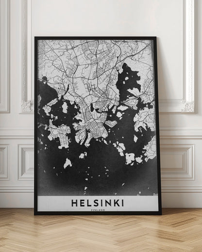 A modern black and white map of Helsinki, Finland, presented in a black frame. The city's street grid is detailed in white lines on a textured black background representing the water, creating a high-contrast, minimalist design. The name 'HELSINKI' is printed in bold capital letters at the bottom on a white banner. Artwork