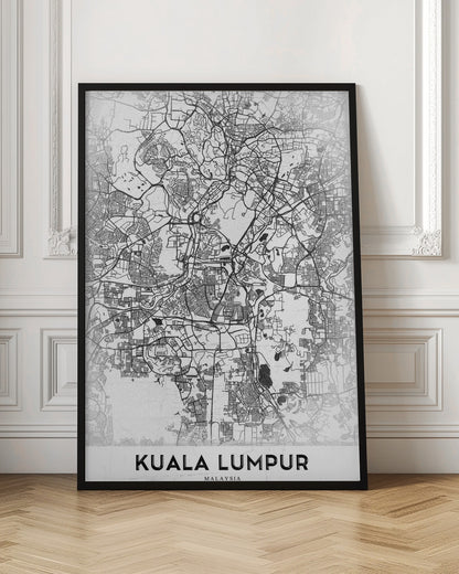 A minimalist black and white street map of Kuala Lumpur, displayed in a black frame. The map shows a detailed network of roads and city blocks on a textured white background. The name "KUALA LUMPUR" is printed in a bold, modern font at the bottom. Decor