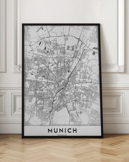 A minimalist black and white street map of Munich, Germany, presented in a thin black frame. The map shows intricate road networks and geographical features on a textured white background, with the word 'MUNICH' in a bold, black, sans-serif font at the bottom. Wall Art
