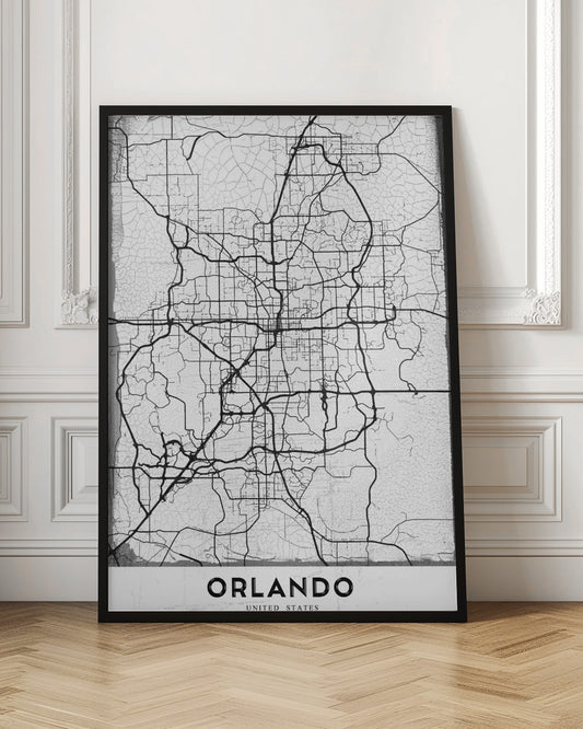 A minimalist black and white street map of Orlando, Florida, displayed in a black frame. The map consists of black lines representing the city's road network on a distressed, crackled white background. At the bottom, the word 'ORLANDO' is printed in a bold, black, sans-serif font on a white banner. Poster