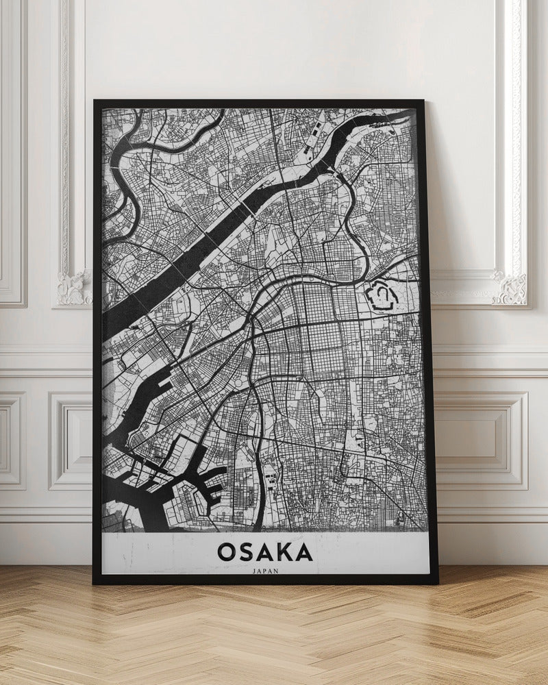 A framed black and white map of Osaka, Japan. The map details the city's streets, blocks, and rivers in a modern, graphic style. At the bottom, a white border contains the word 'OSAKA' in a bold, black, sans-serif font. Print