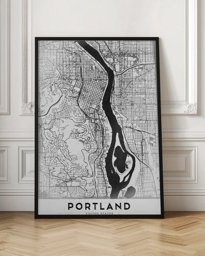 A framed, black and white street map of Portland, Oregon. The map is stylized with black lines for streets on a textured white background, and the Willamette River is depicted in solid black. The word 'PORTLAND' is written in a bold, black, sans-serif font at the bottom. Decor